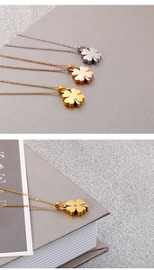 Macro detail of three-color titanium steel clover pendants in gold, silver and rose gold