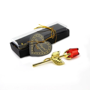 Dettaglio di rosa in cristallo rosso con stelo dorato in elegante confezione regalo