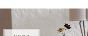 Künstlerische Lotus-Deko in Gold und Braun vor einer weißen verputzten Wandstruktur