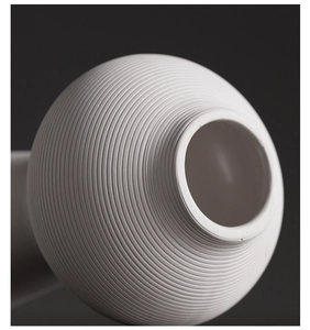 Macro-opname van een minimalistische witte keramische vaas met ribbeltextuur en matte lak