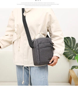 Detail of dark grey oxford fabric shoulder bag with dual zipper pockets and nylon strap