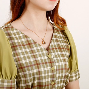 Elegant gold round zircon pendant necklace worn by a model on a clean white background