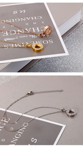 Detailed shot of three minimalist titanium steel necklaces with sparkling zircon pendants