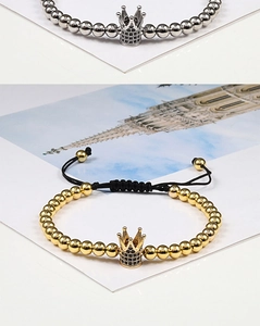 Detail view of woven crown bracelets in gold and silver with zircon paved charms