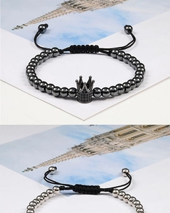 Detail view of woven beaded bracelets with zircon crown charms in black and silver finishes