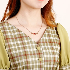 Collier en or rose avec pendentif coeur rouge et motif de battement de coeur sur modèle