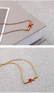 Détails de colliers en or rose et or avec pendentifs cœur rouge et motif de battement de cœur