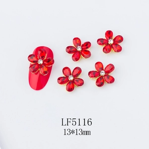 Macro view of red 3D flower nail charm with white crystal and gold alloy base