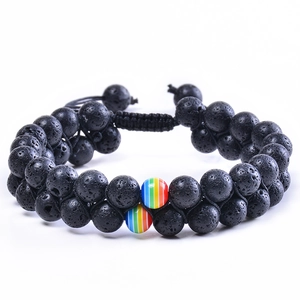 Macro shot of double-layer black lava stone bracelet with rainbow beads and braided cord