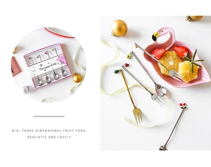Detailed view of stainless steel fruit spoons and forks set with cute 3D toppers