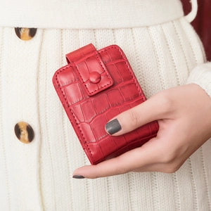 Rote Mini-Kosmetiktasche aus Kroko-Leder mit Spiegel und Druckknopf in der Hand