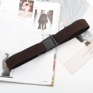 Brown elastic wide belt with black buckle detail on a fashion magazine background