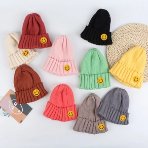 Kids warm knit beanies in assorted colors with yellow smiley face patch embroidery
