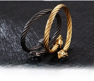 Vue détaillée de bracelets en câble d'acier torsadé avec têtes de léopard dorées et noires