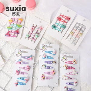 Detail bunter Macaron-Haarspangen für Mädchen mit Einhorn- und Fruchtmotiven auf Karte
