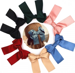 Detailed view of large satin bow hair clips in six elegant colors with spring clips