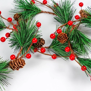 Christmas wreath with artificial pine needles, red berries and natural pine cones on white