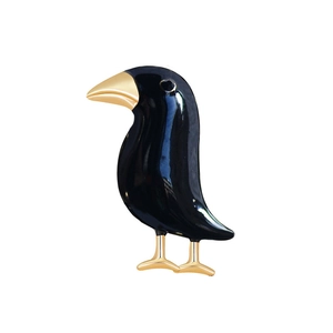 Elegant black raven brooch with gold accents on a clean white background