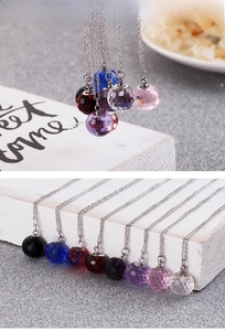 Macro detail of faceted crystal ball pendants in eight colors on stainless steel chains
