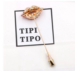 Detailed view of lipstick red lips brooch with sparkling rhinestones and gold hearts