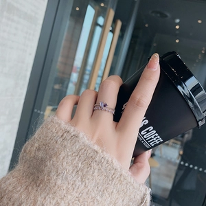 Detail of a double-layered silver ring with purple heart-shaped stone and zircon inlay