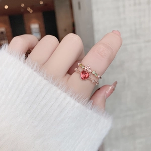 Close-up of a rose gold layered ring set with red heart gem and colorful floral accents