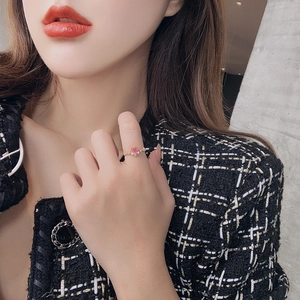 Close-up of elegant gold ring with pink heart crystal gemstone on model's finger