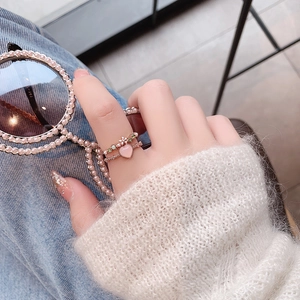 Detail of Korean style floral and pink heart crystal rings set in rose gold finish