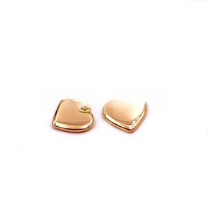 Close-up of heart-shaped gold pendants with polished finish and circular bail for DIY jewelry