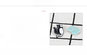 Detail view of cat enamel pins with material specs: zinc alloy, plating and enamel process