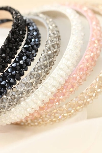 Close-up of slim crystal headbands in assorted colors with shimmering faceted beads