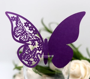 Detail of dark purple 3D butterfly laser cut card on a glass for wedding decor