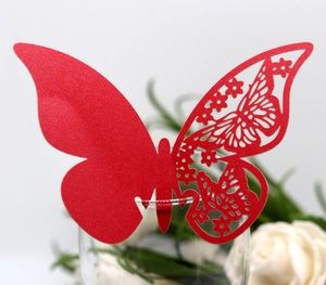 Detail of red hollow butterfly card placed on a wine glass for party table decoration