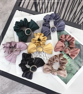 Close-up of colorful silk scrunchies with elegant rhinestone-encrusted round buckles