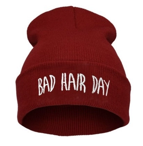 Dettaglio del berretto in maglia bordeaux con ricamo bianco Bad Hair Day