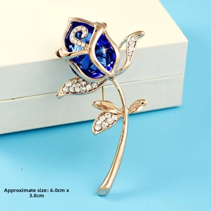 Detail of rose brooch with blue crystal and golden leaves showing 6.0cm x 3.8cm size
