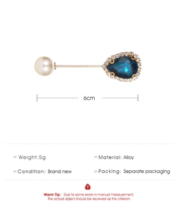 Detailed view of water drop blue gemstone brooch with pearl and gold alloy pin