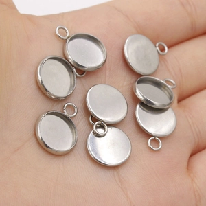 Polished stainless steel round pendant tray settings for jewelry making on palm