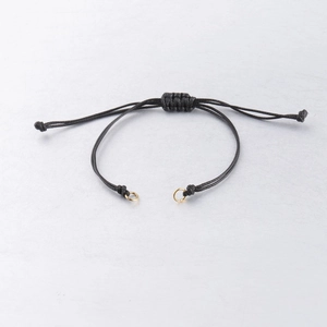 Detail of adjustable 0.8mm black waxed cord bracelet with golden metal rings