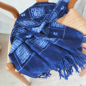 Deep blue tie-dye cotton scarf with geometric patterns and long tassels on a chair