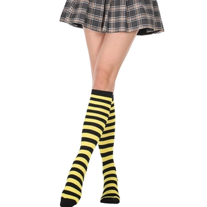 Detailed close-up of yellow and black striped knee-high socks worn with a pleated skirt