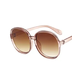 Classic round oversized sunglasses with transparent pink frames and brown gradient lenses