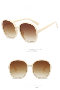 Detailed view of cream white oversized round sunglasses with tea gradient lenses
