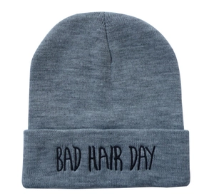Dettaglio del berretto in maglia grigia con ricamo nero 'BAD HAIR DAY' sul bordo