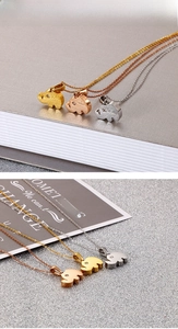 Detailed view of elephant pendants in gold, rose gold and silver on a textured background