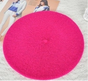 Flat lay of rose red wool beret on white lace fabric for autumn and winter style