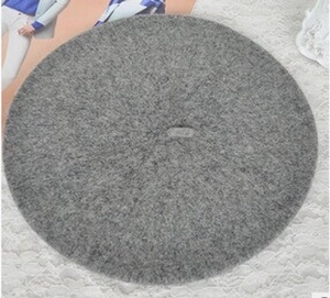 Detailed flat lay of a solid grey wool felt beret on a vintage lace background