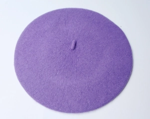 Detail shot of a purple wool beret showing the soft texture and classic top stem design