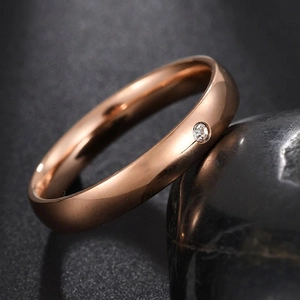 Detail of rose gold stainless steel ring with bezel set round cubic zirconia stone