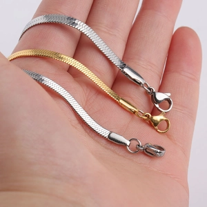 Close-up of gold and silver flat snake bone chain bracelets with secure lobster clasps